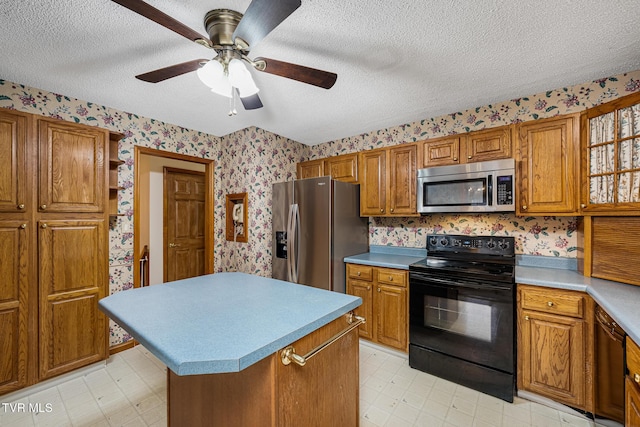 kitchen featuring black appliances, ceiling fan, a kitchen island, and a textured ceiling