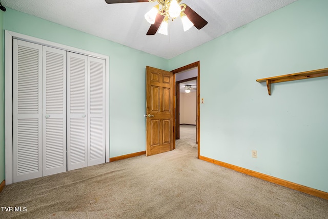 unfurnished bedroom with a textured ceiling, a closet, ceiling fan, and light colored carpet