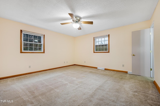 carpeted empty room with ceiling fan and a textured ceiling