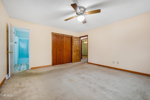 unfurnished bedroom featuring ceiling fan, a closet, light colored carpet, and a textured ceiling