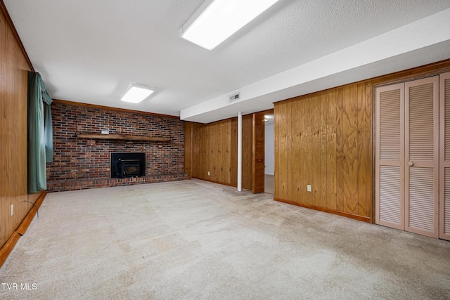 unfurnished living room featuring a wood stove, light carpet, brick wall, a textured ceiling, and wooden walls