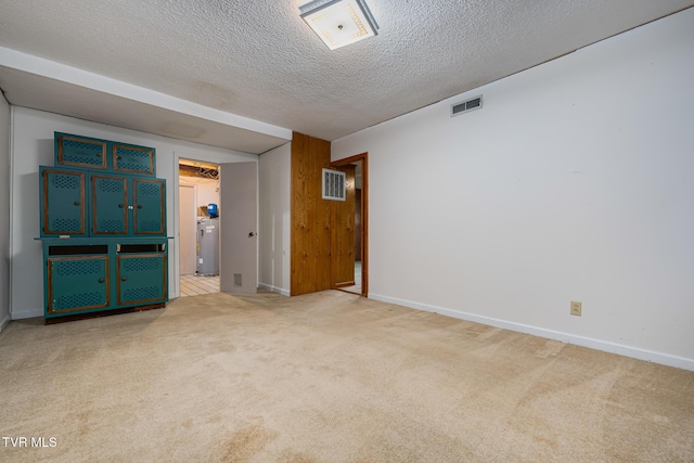 unfurnished room featuring carpet, a textured ceiling, and water heater