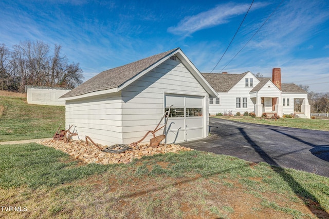 view of outdoor structure with a yard and a garage