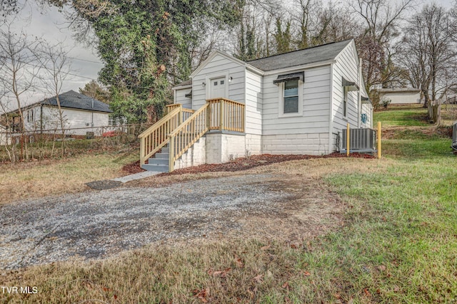 exterior space featuring central air condition unit and a front lawn