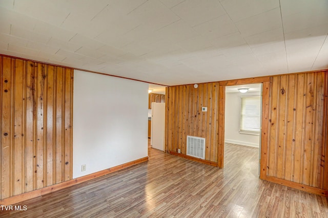 empty room featuring hardwood / wood-style floors and wood walls