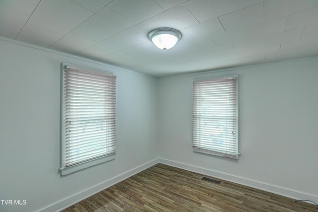 empty room featuring dark hardwood / wood-style floors and crown molding