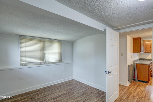 empty room featuring a textured ceiling and light wood-type flooring