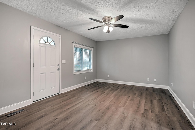 entryway with ceiling fan, dark wood-type flooring, and a textured ceiling