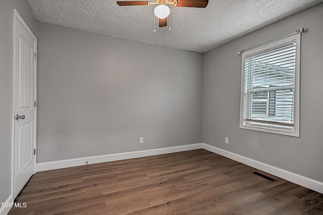 unfurnished room with dark hardwood / wood-style flooring and a textured ceiling