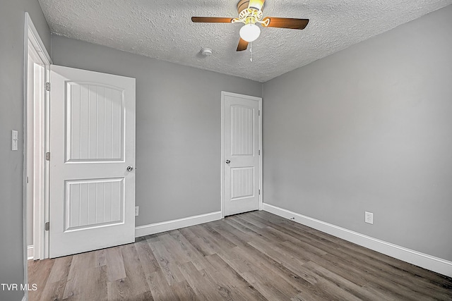 unfurnished bedroom featuring ceiling fan, a textured ceiling, and light hardwood / wood-style flooring