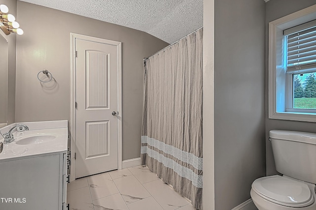 bathroom with a shower with curtain, vanity, a textured ceiling, and toilet