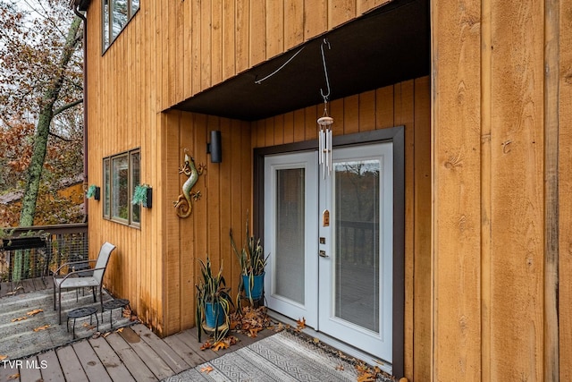 view of exterior entry featuring french doors and a deck