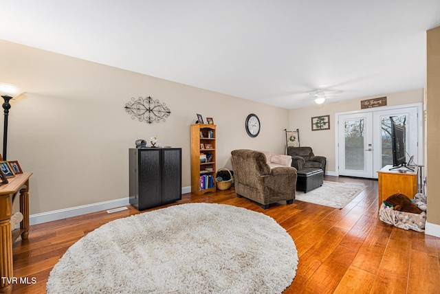 living room featuring wood-type flooring, french doors, and ceiling fan