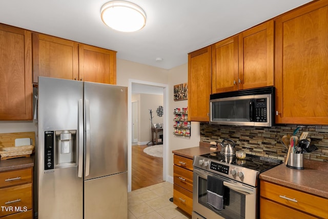 kitchen with decorative backsplash, light hardwood / wood-style flooring, and stainless steel appliances