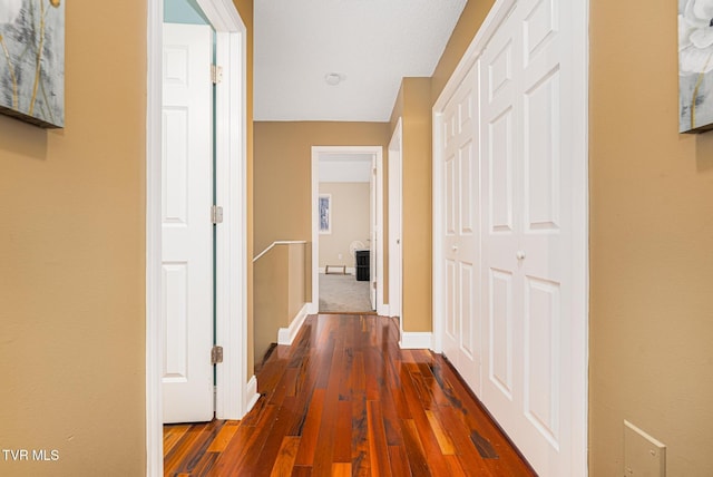 hallway with dark hardwood / wood-style flooring