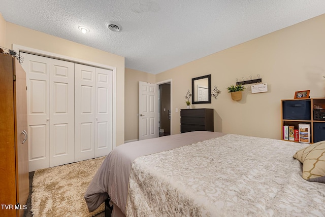 carpeted bedroom featuring a closet and a textured ceiling