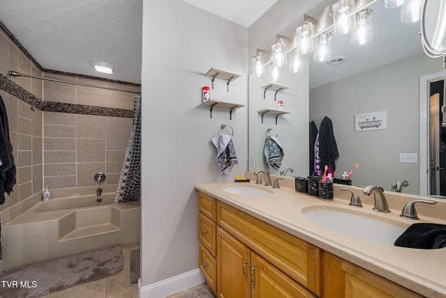 bathroom featuring tile patterned floors, vanity, a textured ceiling, and tiled shower / bath