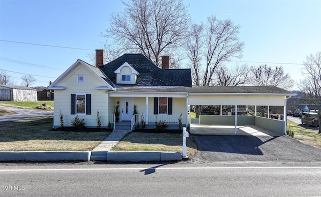 view of front of property featuring a front yard, a carport, and covered porch