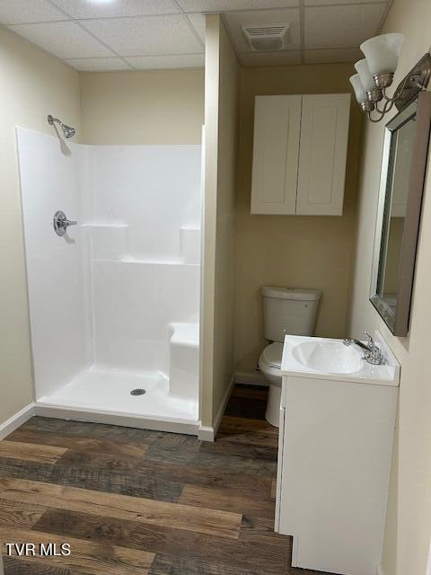 bathroom featuring a drop ceiling, wood-type flooring, and walk in shower