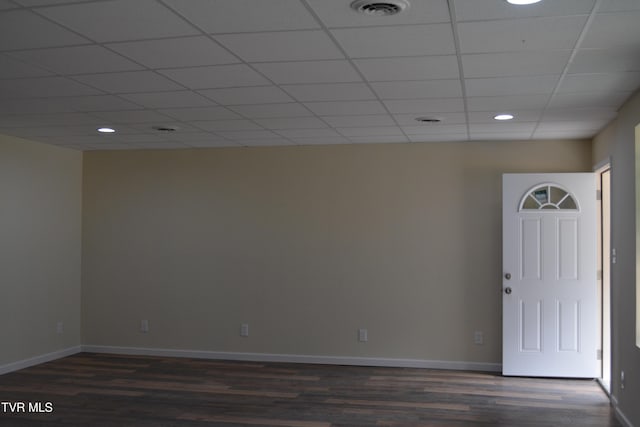 spare room with a drop ceiling and dark hardwood / wood-style floors