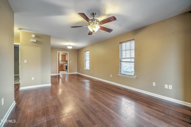 empty room featuring ceiling fan and dark wood-type flooring