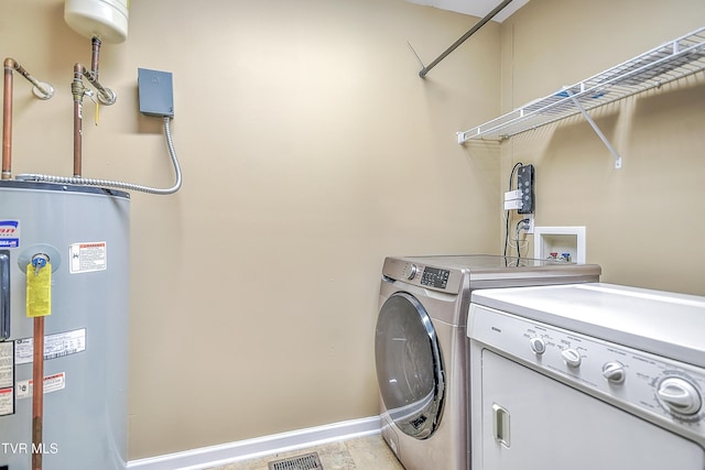 clothes washing area featuring washer and dryer and water heater