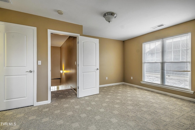 unfurnished bedroom with light colored carpet