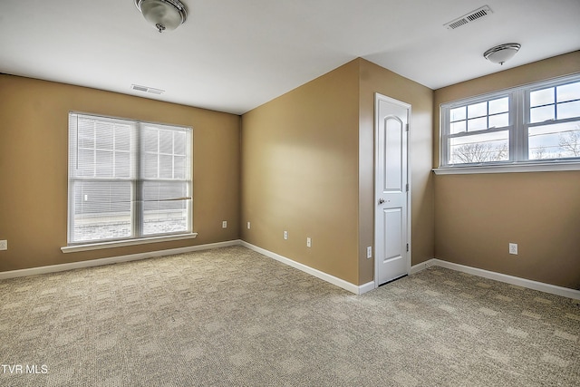 spare room with plenty of natural light and light colored carpet