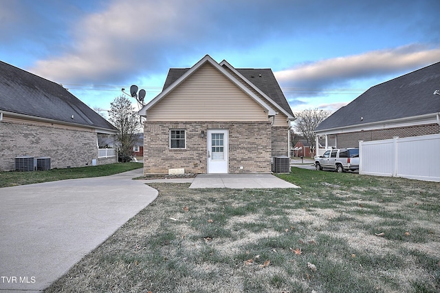 back of house featuring a yard, a patio, and central AC