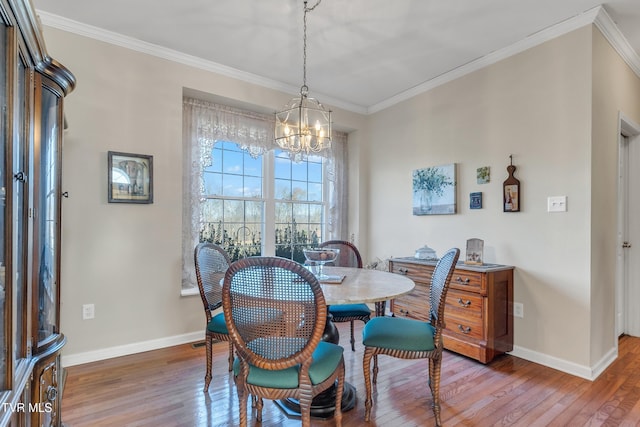 dining space with hardwood / wood-style flooring, an inviting chandelier, and ornamental molding