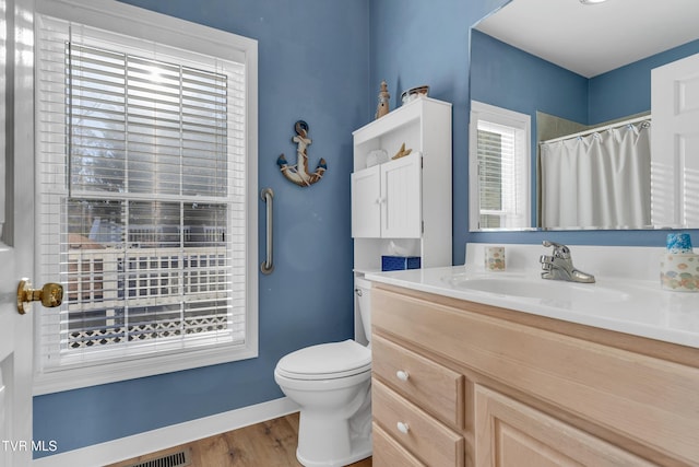 bathroom with walk in shower, hardwood / wood-style floors, vanity, and toilet