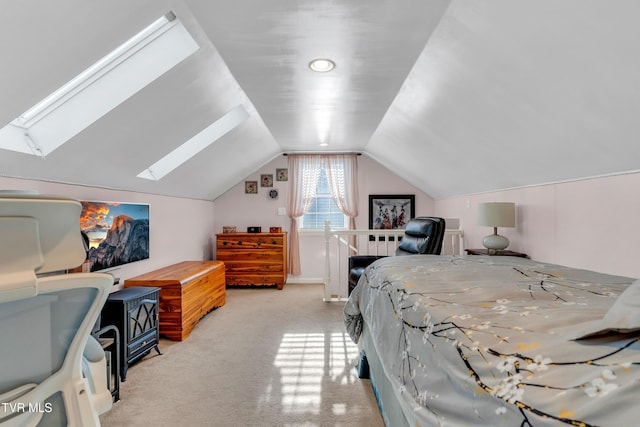 bedroom with vaulted ceiling with skylight and light colored carpet