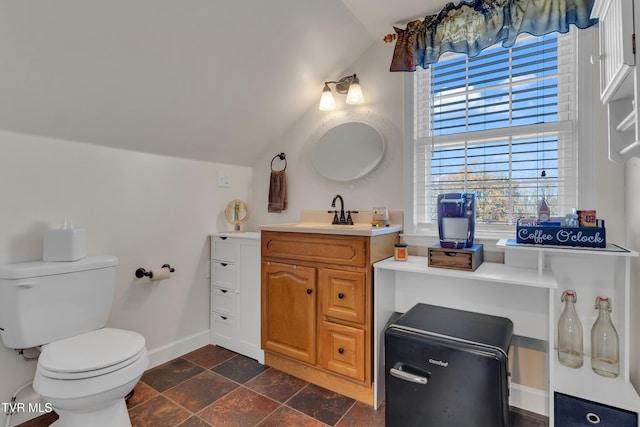 bathroom featuring vanity, toilet, and lofted ceiling