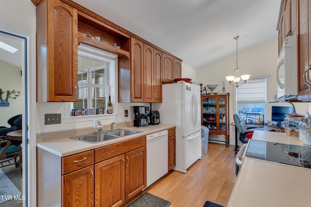 kitchen with white appliances, sink, vaulted ceiling, light hardwood / wood-style flooring, and decorative light fixtures