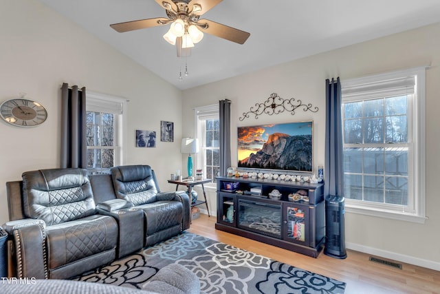 living room with ceiling fan, a healthy amount of sunlight, lofted ceiling, and wood-type flooring