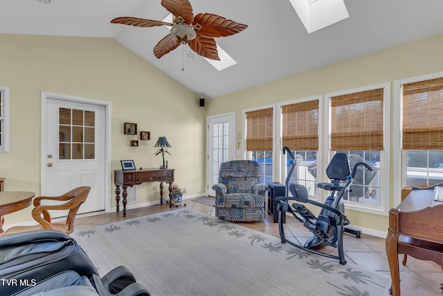 living room with ceiling fan, lofted ceiling with skylight, and light tile patterned floors