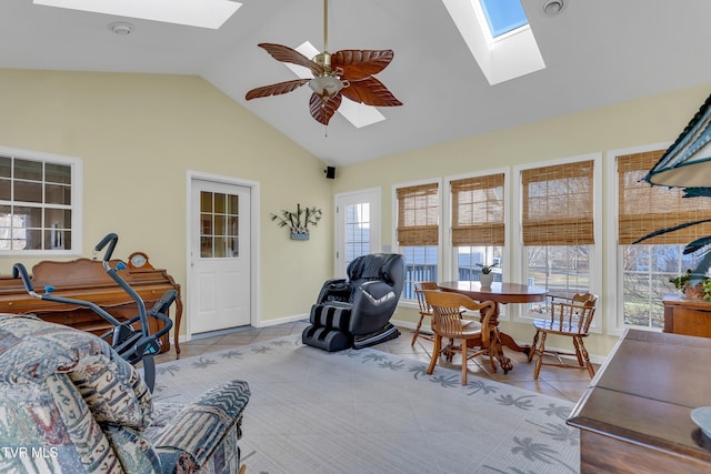 living room featuring a wealth of natural light, ceiling fan, light tile patterned floors, and a skylight