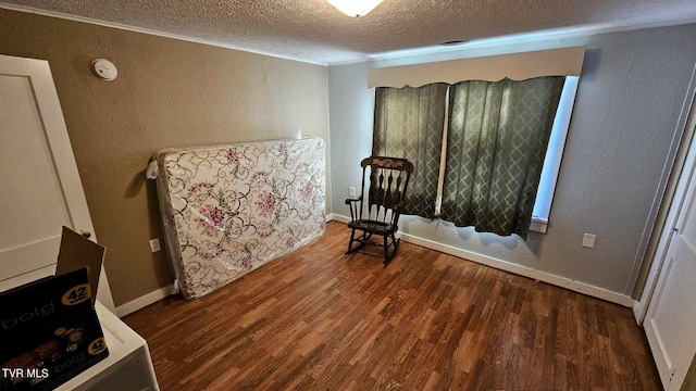 unfurnished room with a textured ceiling, dark hardwood / wood-style floors, and crown molding