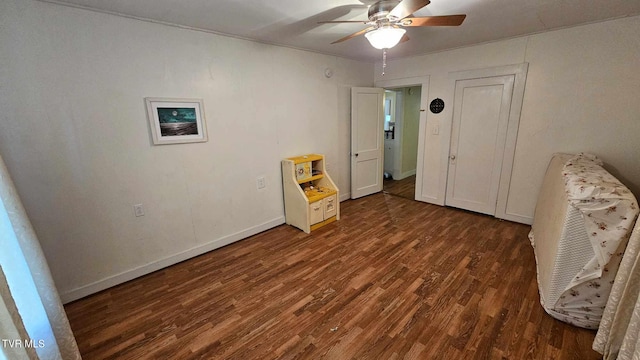 unfurnished bedroom featuring ceiling fan and dark wood-type flooring