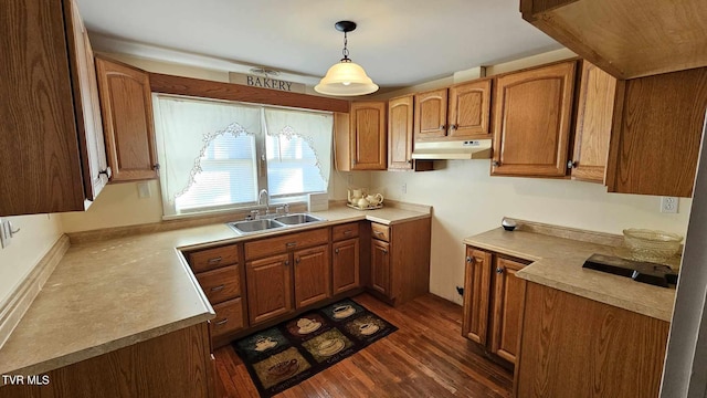 kitchen with pendant lighting, sink, and dark wood-type flooring