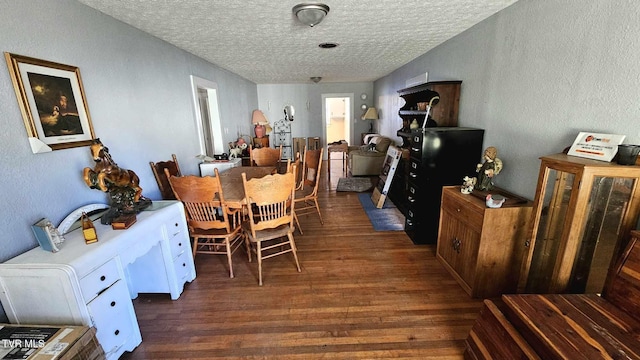 dining room with a textured ceiling and dark wood-type flooring