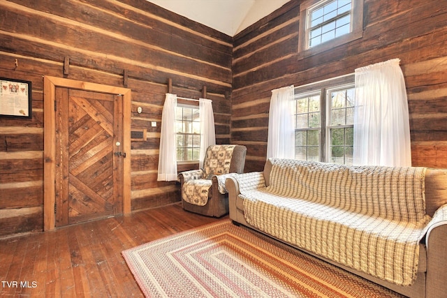 unfurnished room featuring hardwood / wood-style flooring, wooden walls, and vaulted ceiling