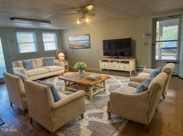 living room featuring a paneled ceiling, plenty of natural light, and ceiling fan