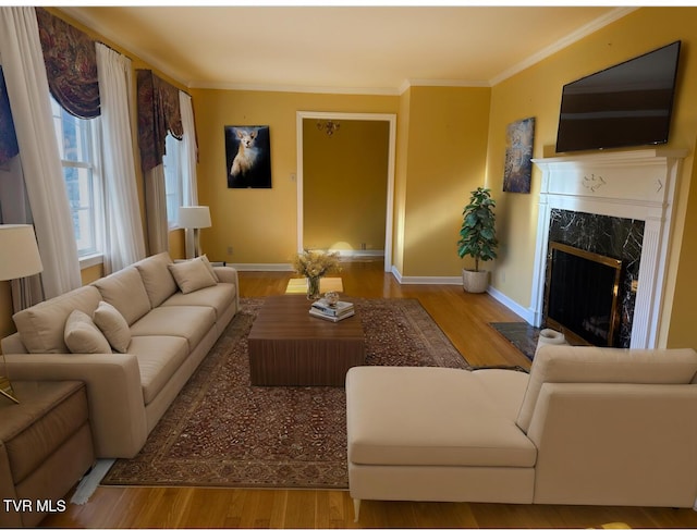 living room with a high end fireplace, light wood-type flooring, and ornamental molding