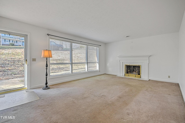 unfurnished living room with a healthy amount of sunlight, light colored carpet, and a textured ceiling