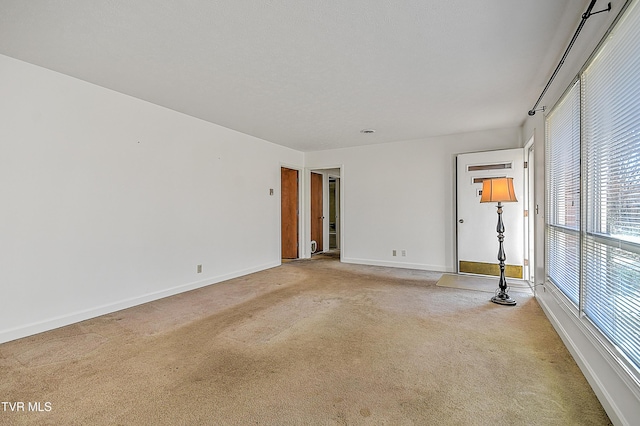 spare room featuring light carpet