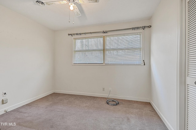 carpeted spare room featuring ceiling fan