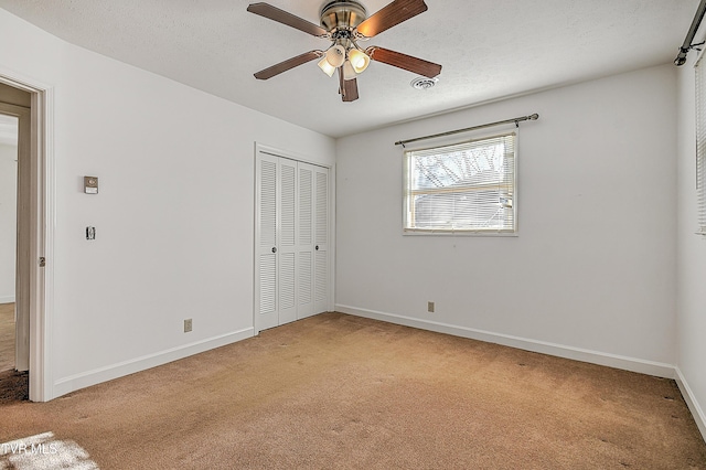 unfurnished bedroom featuring ceiling fan, light carpet, and a closet