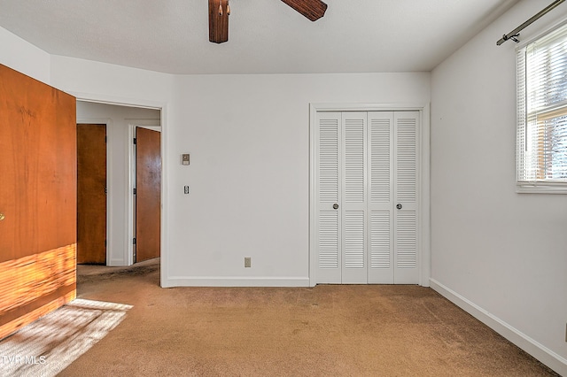 unfurnished bedroom with ceiling fan, a closet, and light colored carpet