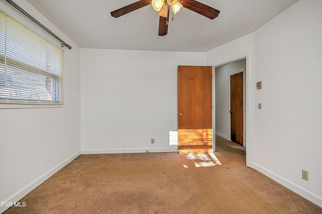 carpeted spare room with ceiling fan